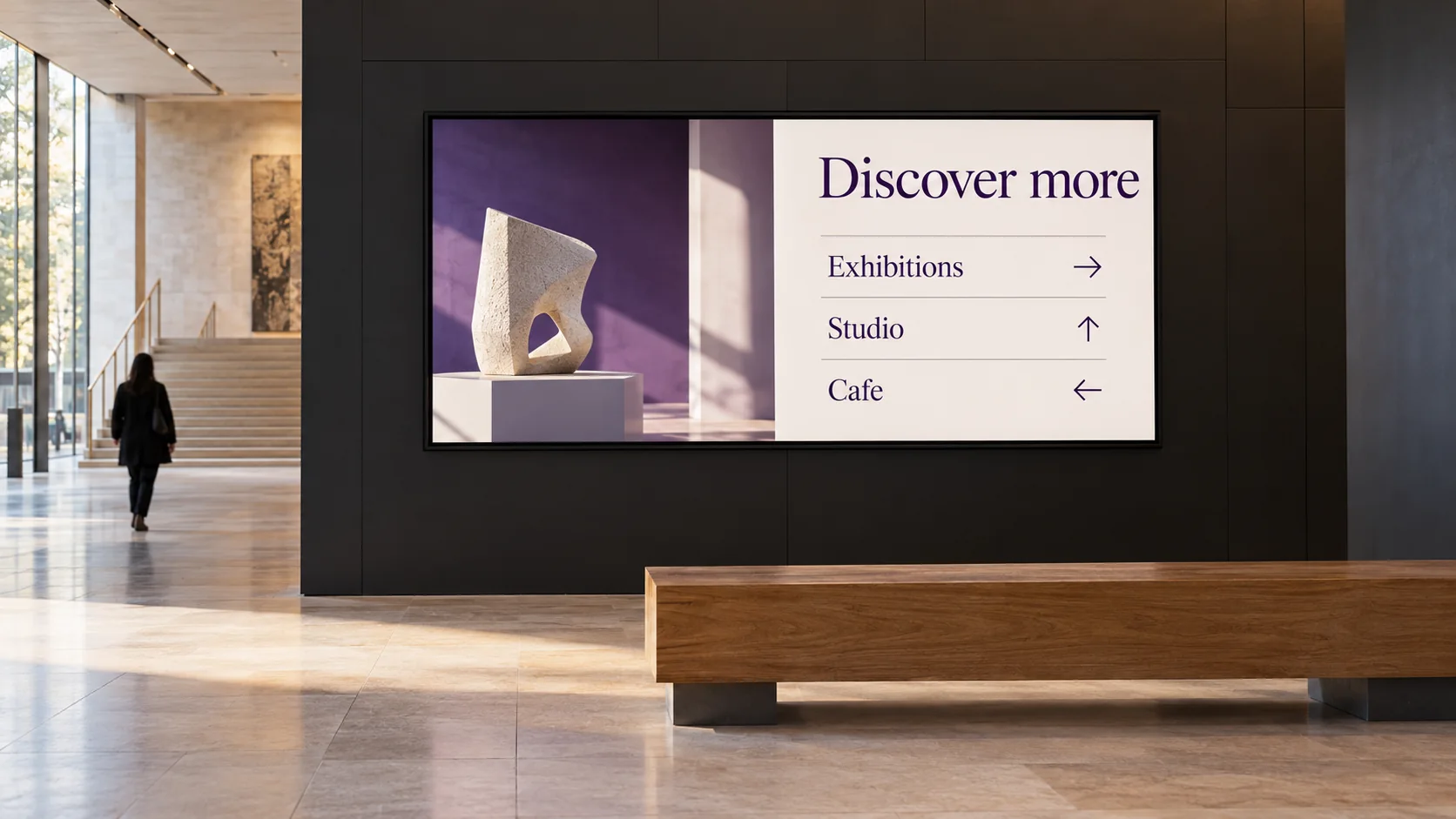 A museum lobby TV showing directions to exhibitions, a studio and the cafe.