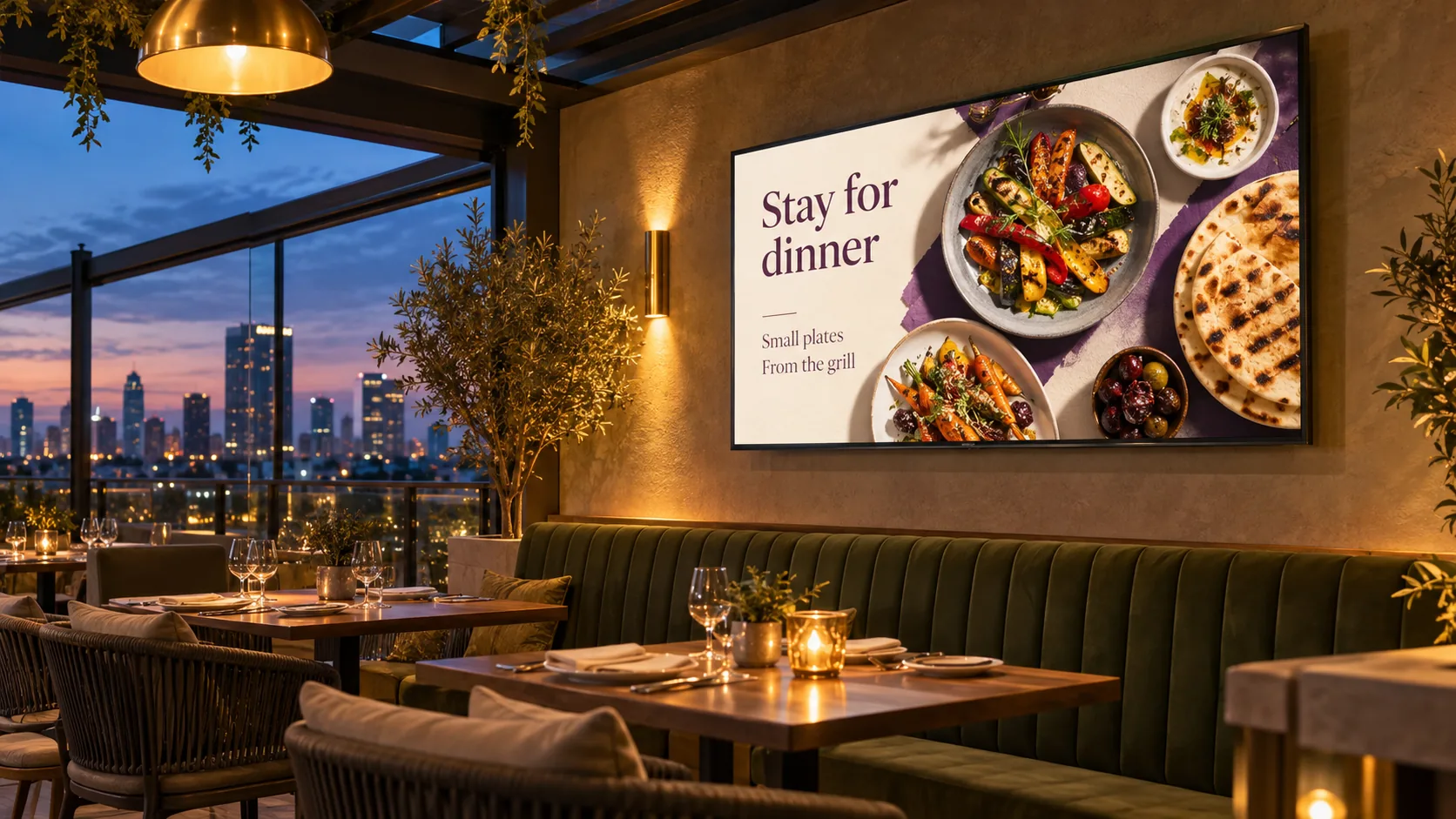 A rooftop restaurant TV showing small plates and grilled food at dusk.